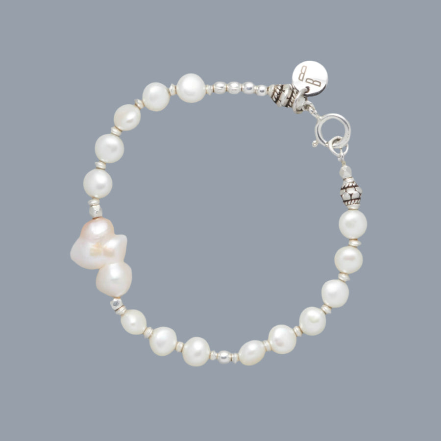 Product Shot the BIANCA Bracelet made with Cultured Freshwater White Pearls and Silver Sterling Elements. As a center-piece there is a beautiful Baroque White Pearl that is shaped like a cloud. 